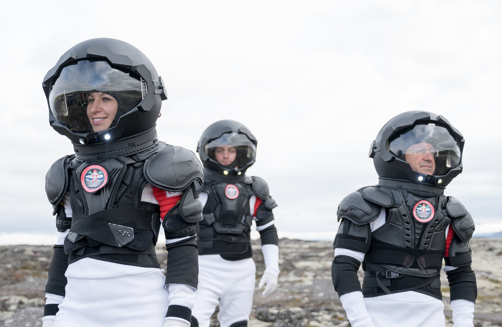 3 astronaughts in space suits on a rocky terrain