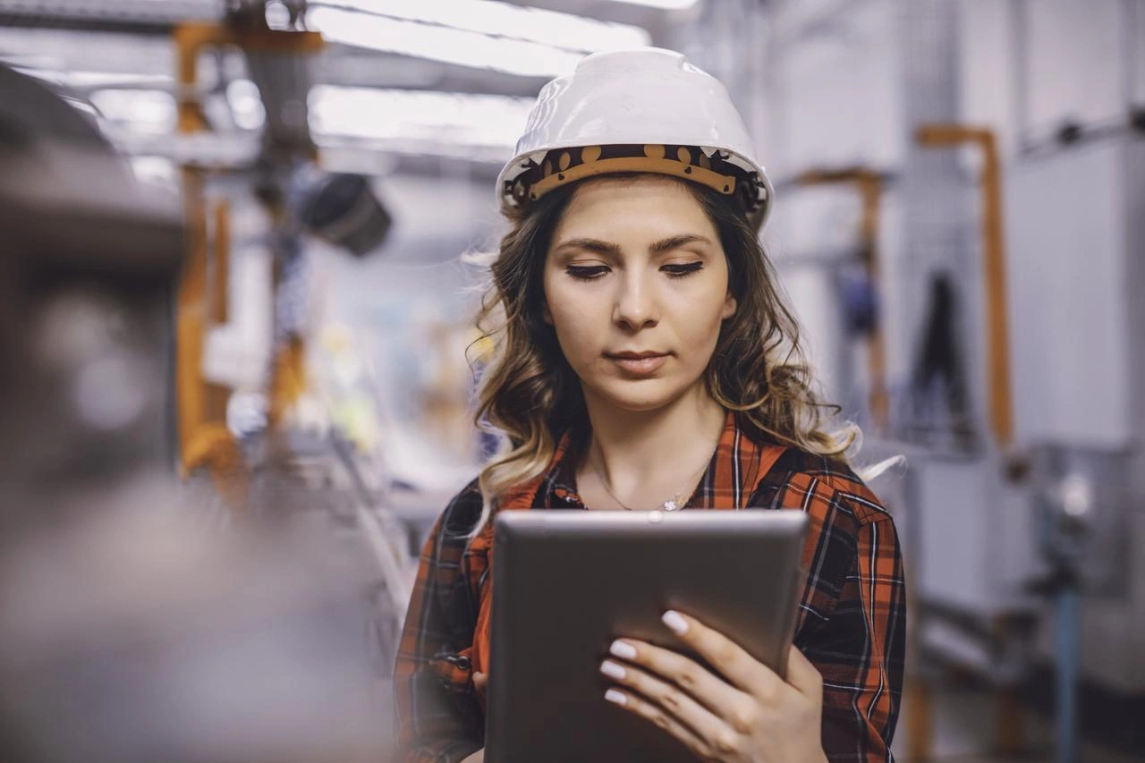 A lady in a factory holding an ipad